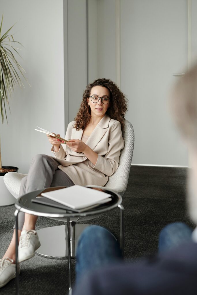 A professional woman in an office setting conducting an interview with confidence.